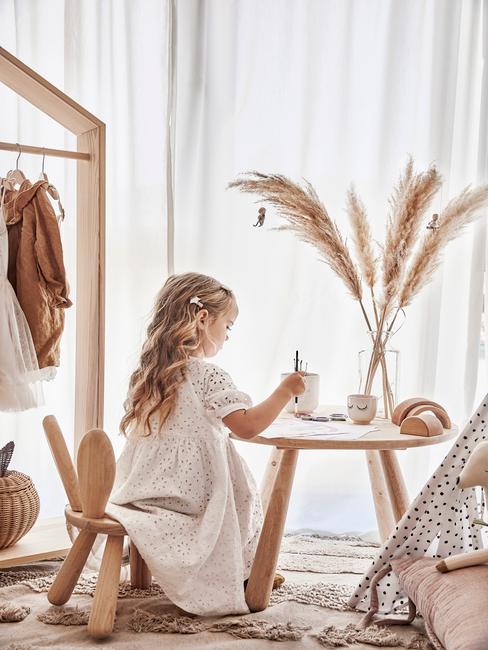 Petite fille assise à une table