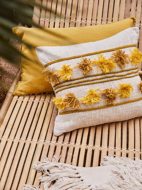 coussins jaunes et blancs sur chaise longue en bamboo