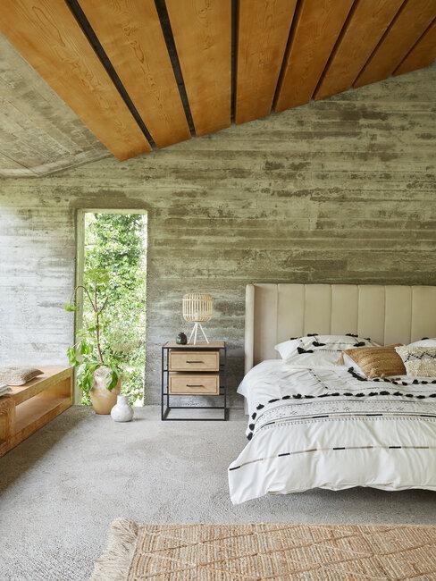 chambre moderne, murs en béton, lit avec tête de lit capitonnée