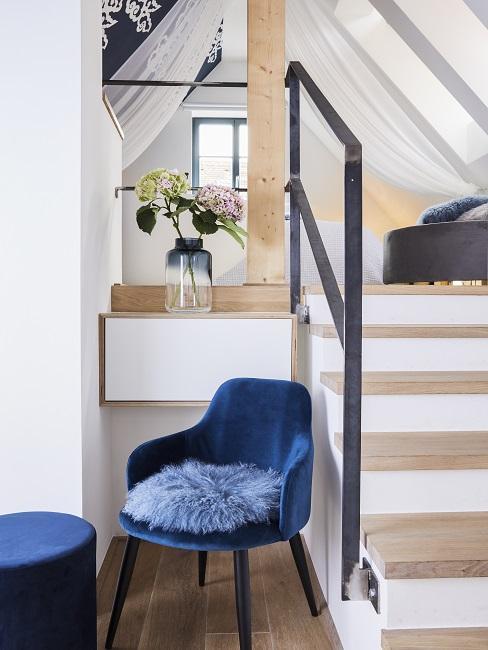 Chaise en velours bleu devant un escalier design