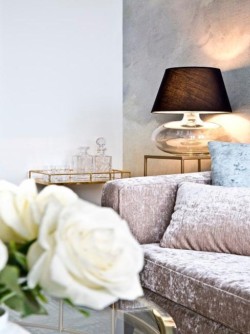 Desserte avec carafes avec lampa à poser en verre et canapé en velours rose