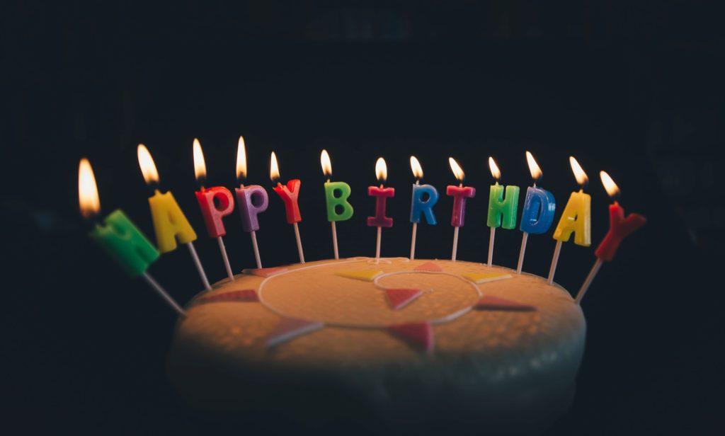 bougies happy birthday allumées sur un gâteau