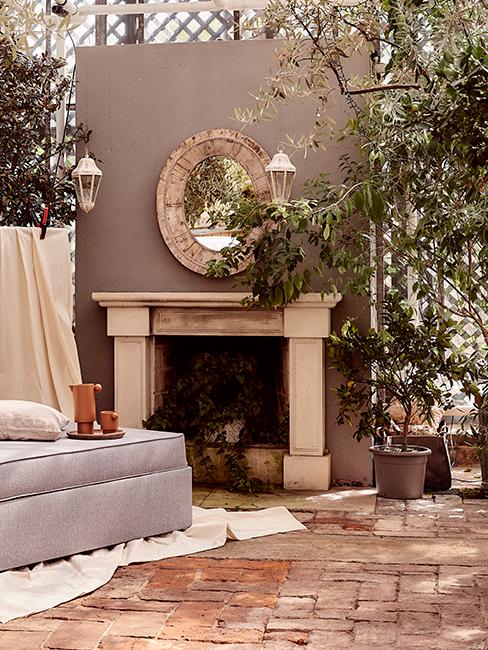 jardin d'hiver avec miroir accroché à un mur, fausse cheminée et plantes