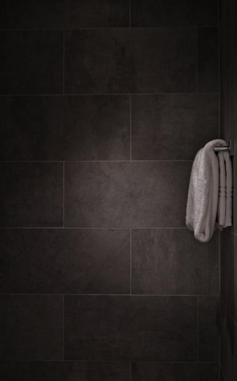 Salle de bain avec carrelage anthracite et serviette blanche