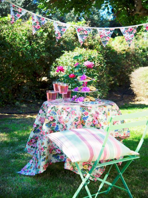 Jardin avec petite table habillée d'une nappe fleurie