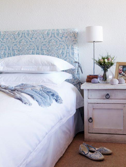 Lit avec tête de lit à imprimé bleu et table de chevet vintage couleur crème