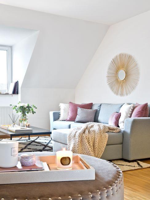 Séjour clair avec murs blancs et canapé avec méridienne gris clair, décoré des coussins et d'un plaid