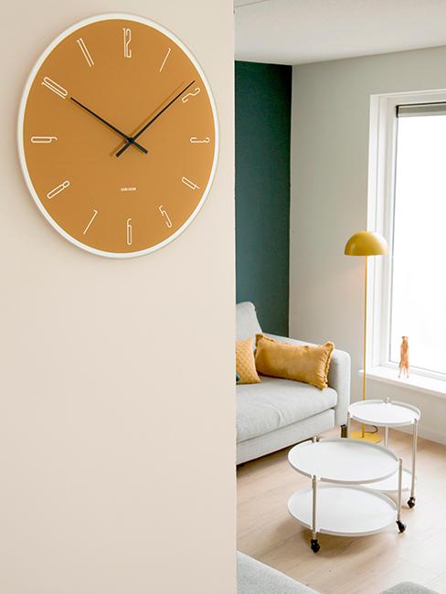 horloge murale jaune accrochée sur un mur blanc
