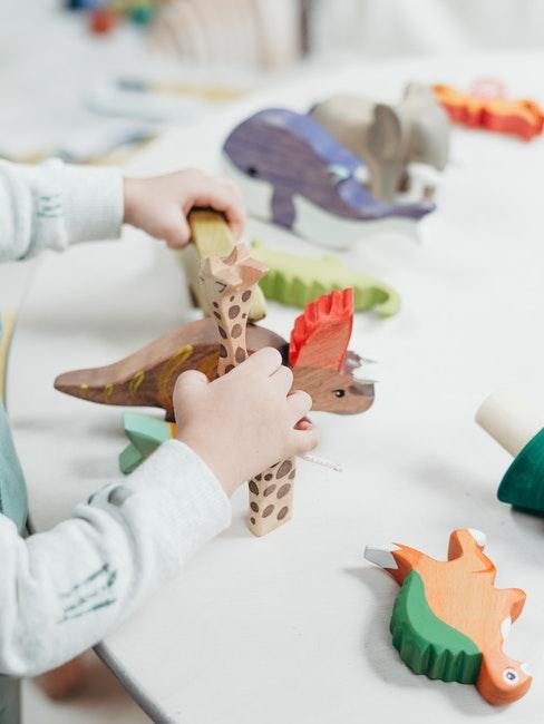 Enfant jouant avec des figurines en bois peintes