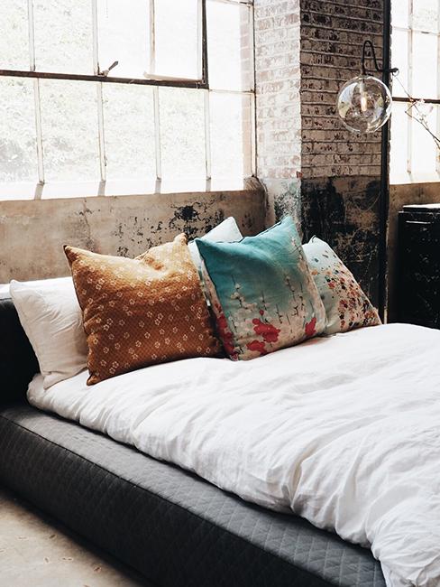 chambre industrielle avec lit et mur en brique