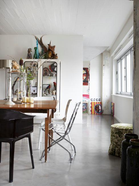 Buffet en bois blanc dans une salle à manger avec table en bois massif et chaises diverses