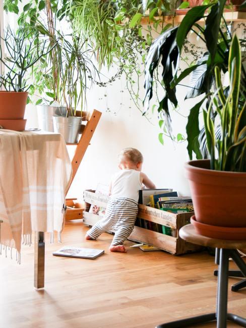 enfant qui cherche des jouets dans une boite en bois