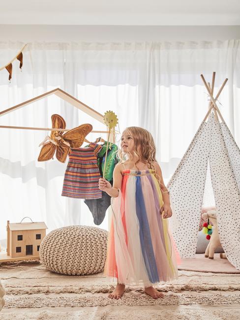 petite fille dans une salle de jeux air rêveuse et joue avec un papillon en ours