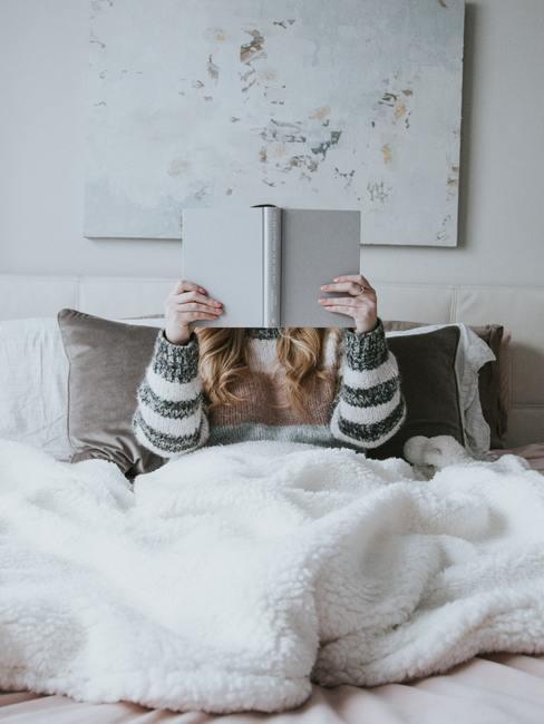 Femme entrain de lire dans un lit