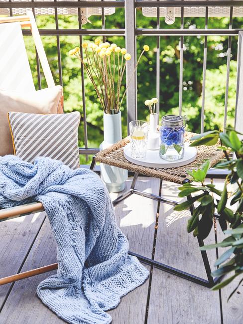 Chaise sur balcon avec plaid bleu