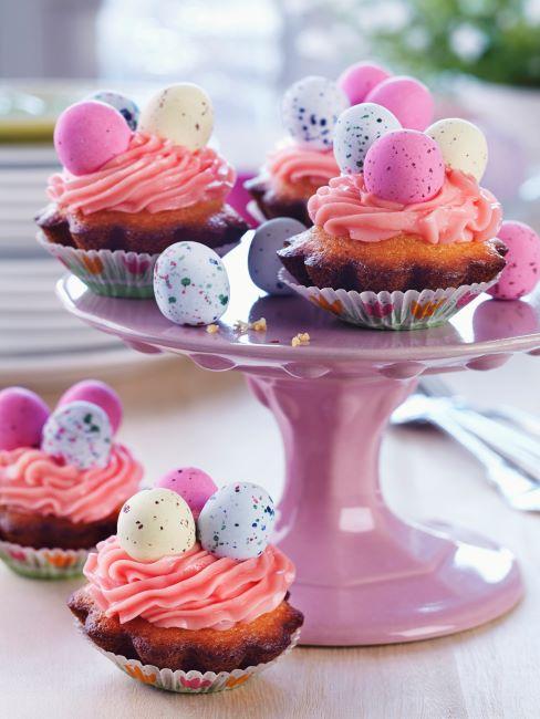Cupcakes avec œufs de chocolat de Pâques sur un présentoir un gâteaux rose