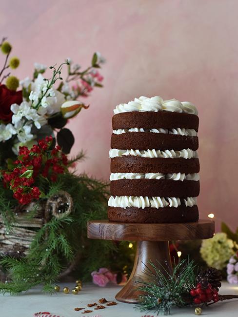 layer cake au chocolat sur un présentoir à pied et avec bouquet de fleurs