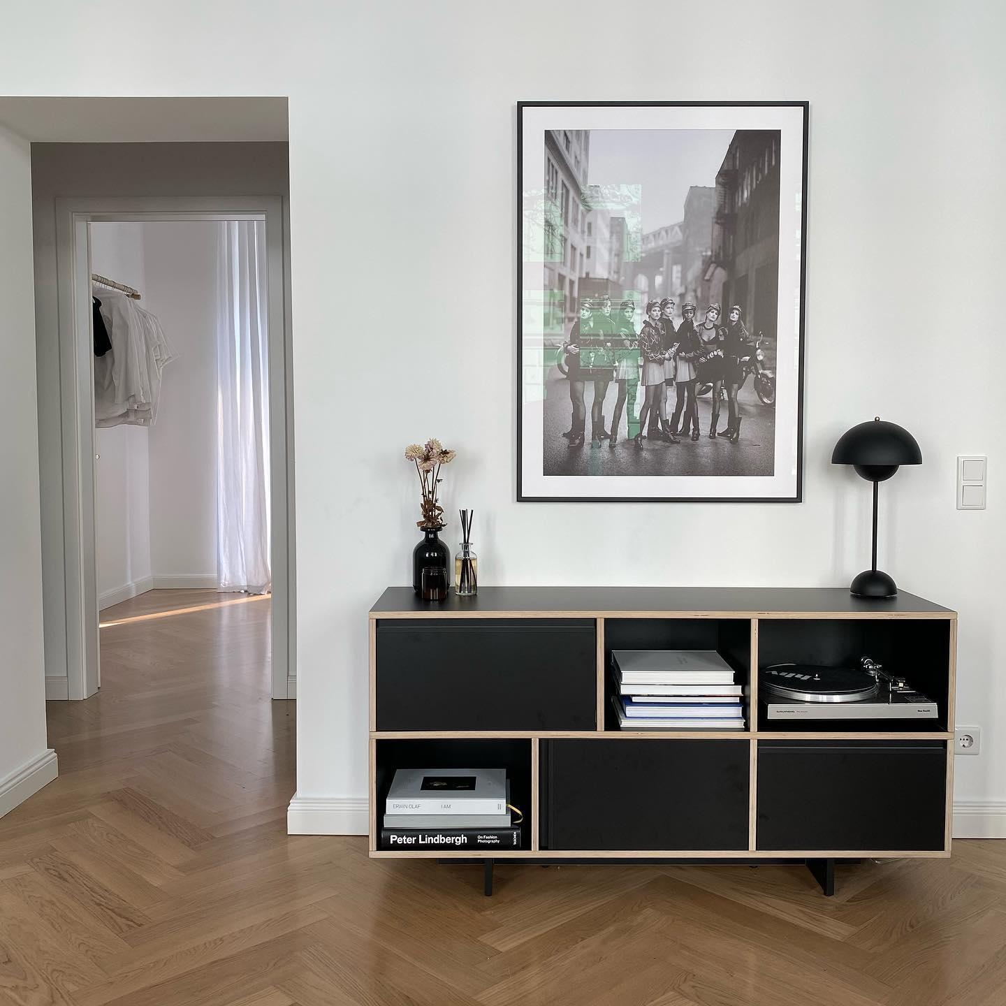 salon avec parquet, mur gris clair et console noire