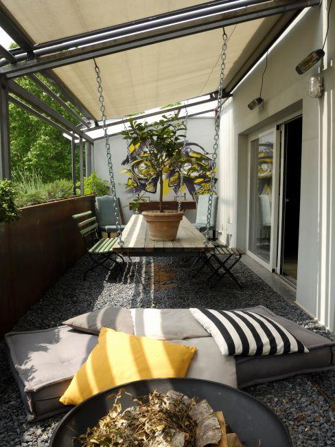 Mobilier extérieur en bois avec coussins décoratifs divers et plantes de balcon