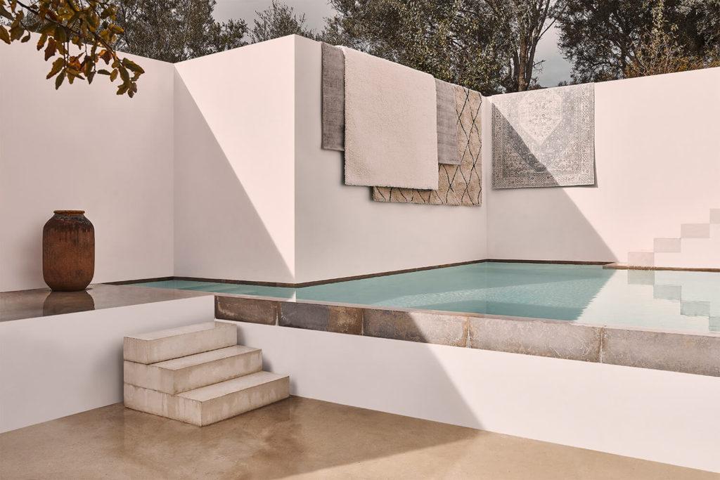 Terrasse épurée avec piscine et tapis marocains