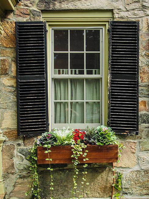 jardinière en bois avec fleurs et plantes sur le rebord d'une fenetre