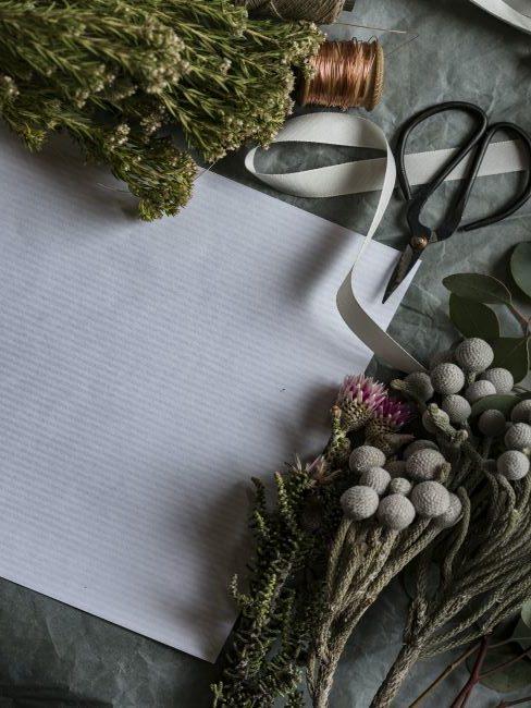 fleurs sechees, ciseaux, ruban et feuille de papier