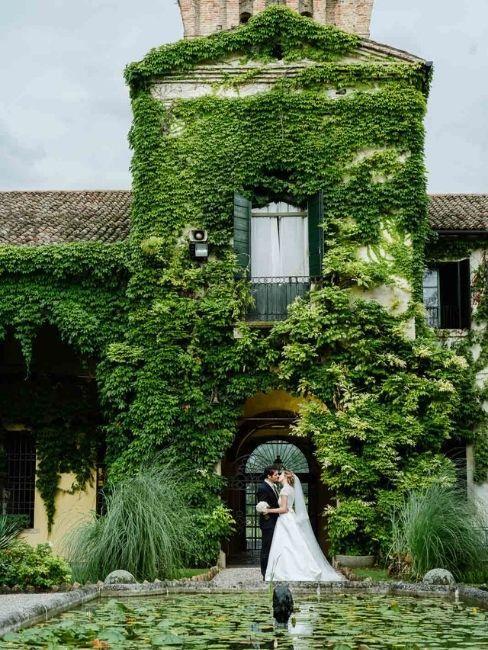 mariage dans un château avec couple de mariés devant un mur végétal