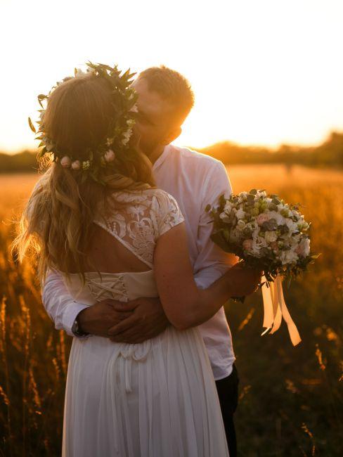 mariés s'embrassant dans les champs pour mariage champêtre chic