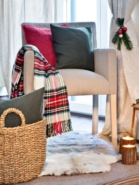 fauteuil beige avec coussins vert et rouge et plaid en tartan