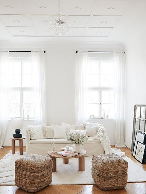 salon lumineux blanc avec canapé beige, pouf en osier et moulures