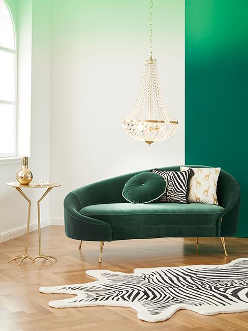 salon chic avec canapé vert foncé en velour, lustre et tapis zèbre