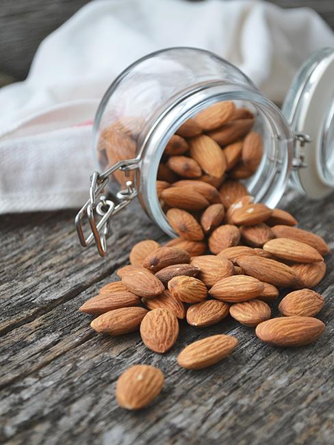 Pot d'amandes renversé sur une table en bois