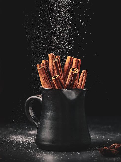 Batons de cannelle dans un pichet noir