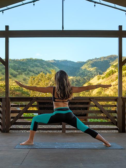 Femme entrain de pratiquer une posture de yoga dans la nature