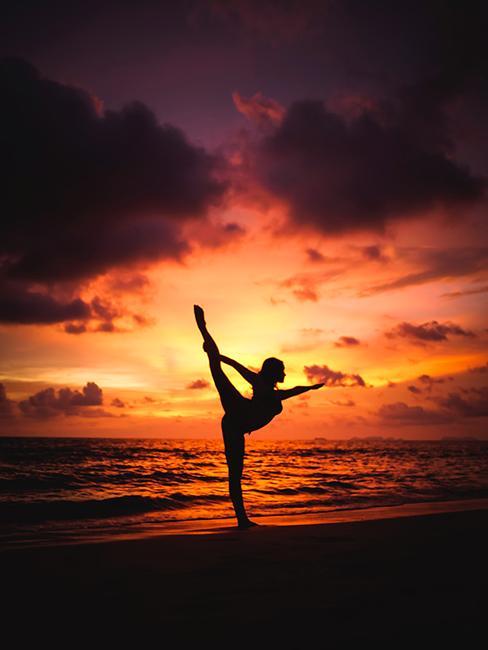 Femme entrain de pratiquer une posture de yoga sur la plage