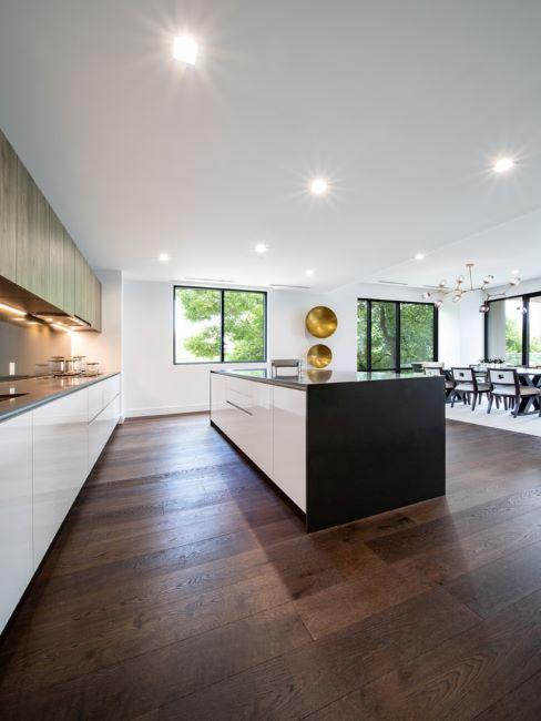 grand cuisine moderne avec sol en bois foncé, ilôt et meubles minimaliste