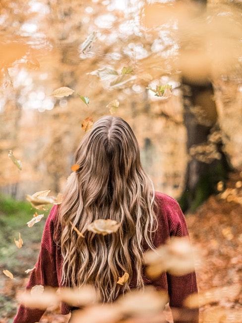 jeune femme se promenant dans un parc en automne