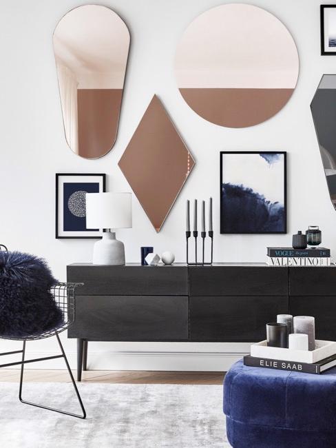 petit salon avec meubles bas, miroirs accrochés au mur et tableaux