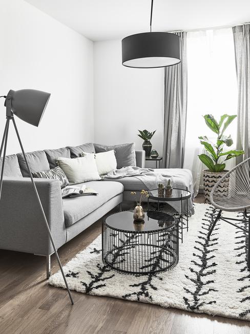 petit salon avec canapé gris, tapis noir et blanc, petites tables basses rondes noire