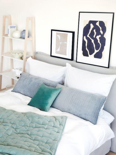 lit boxspring, oreillers, tableaux, étagères, couvre-lit