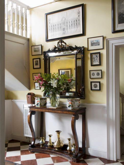 console en bois, miroir mural avec cadre en bois massif, cadre décoratif, cadres photo sur le mur, vases dorés, mur jaune et blanc cassé