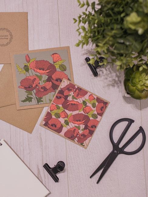 Paire de ciseaux noirs, plante verte et cartes de vœux florales