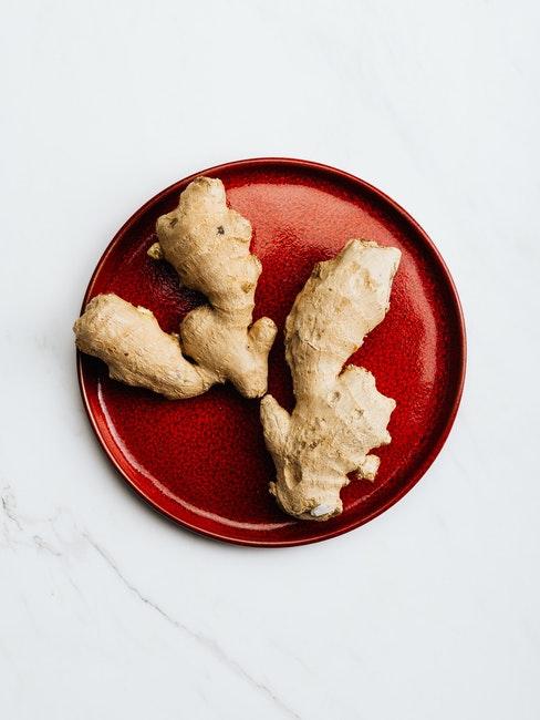 Racine de gingembre sur assiette plate rouge