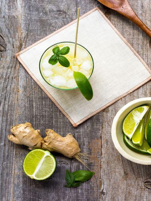 Table en bois, serviette en tissu, verre avec cocktail de citron vert et gingembre