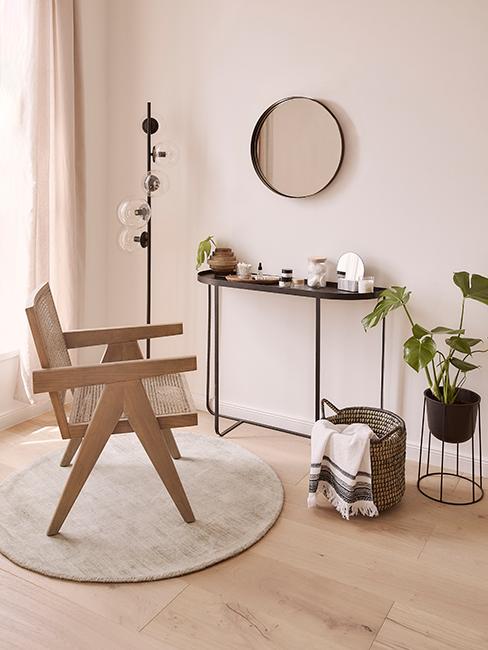 console noir en métal avec miroir rond et chaise en bois et cannage