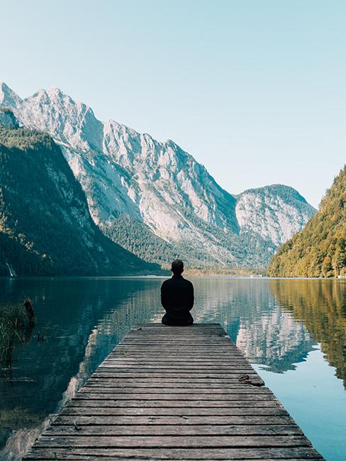 personne assise sur un ponton au bord d'un lac