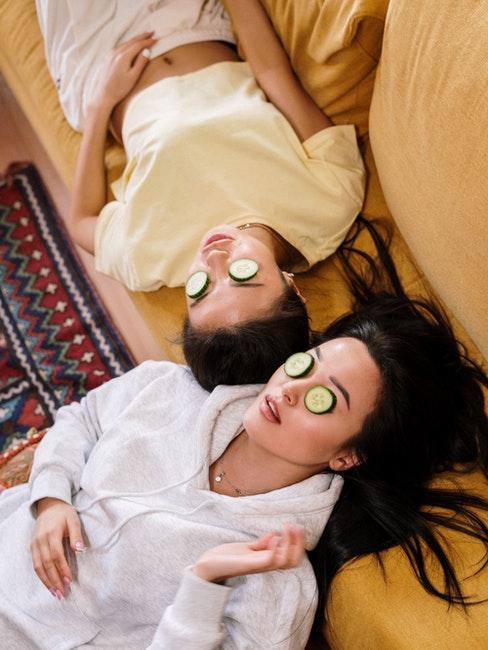 deux femmes allongées avec lamelles de concombre sur les yeux