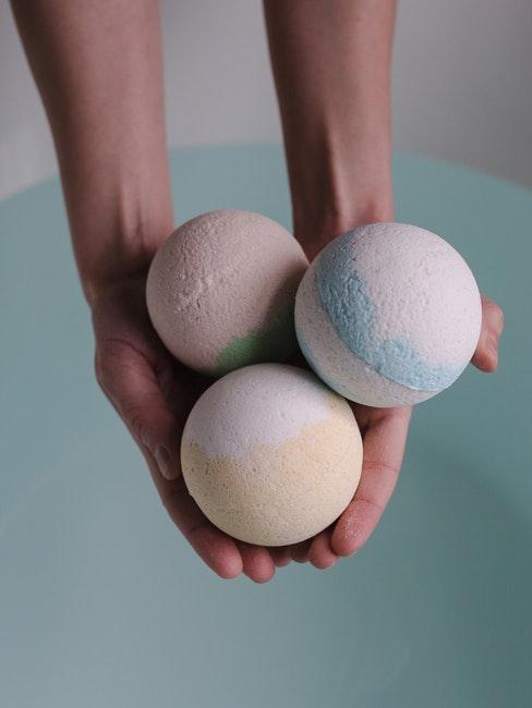 Personne tenant trois boules de bains