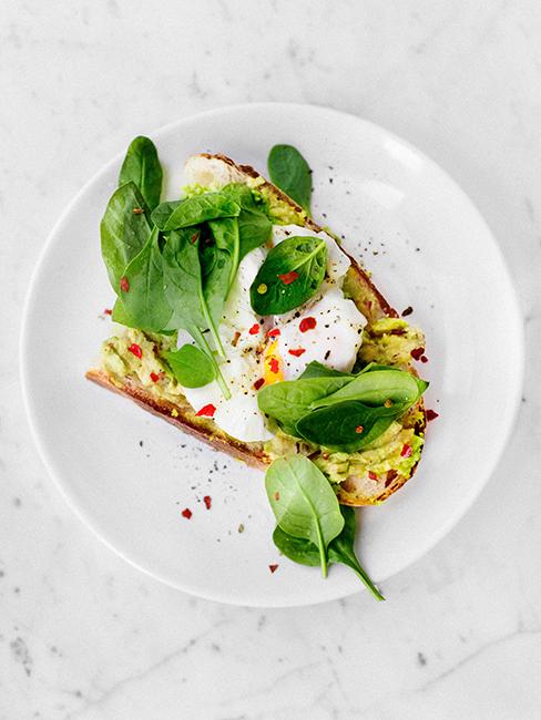 avocado toast avec oeuf poché dans une assiette blanche