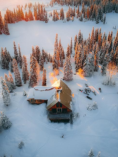chalet au milieu de la neige entouré de sapins